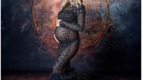 Studio maternity session in Alamogordo featuring dramatic black feather gown with feathered train.