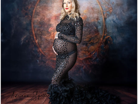 Studio maternity session in Alamogordo featuring dramatic black feather gown with feathered train.