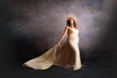 Maternity photo of pregnant woman mochoa chiffon draping fabric standing in front of a charcoal-colored backdrop