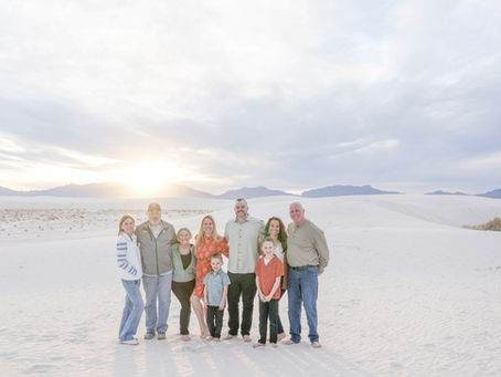 Family portrait under a cloudy sky at White Sands National Park in New Mexico