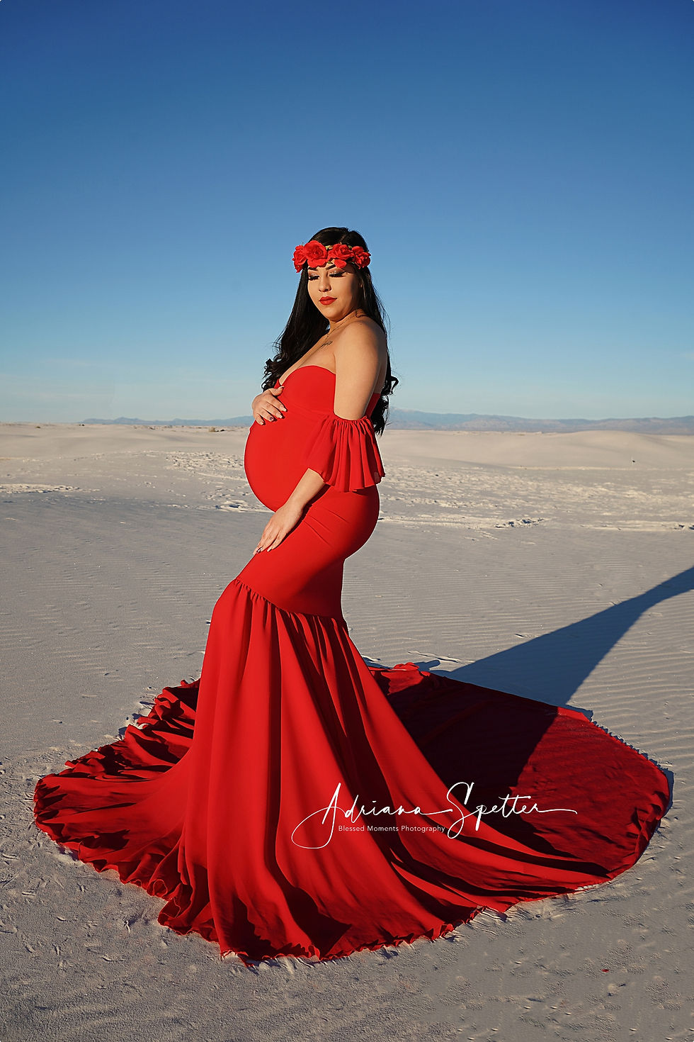Maternity photo with mama looking over her shoulder in a red dress.