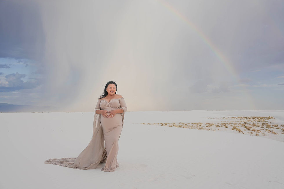 Maternity portrait with rain and a rainbow in the distance at White Sands National Park