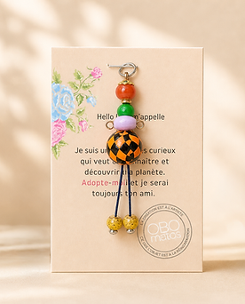 Figurine Obo ‘Celui qui change les règles’, création artisanale en perles orange, vertes et violettes avec motif losange noir et orange, pièce unique faite main