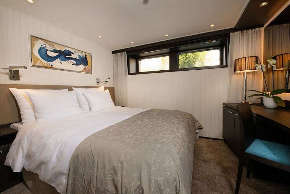 River cruise cabin with a fixed window on a lower deck, representing entry-level cabin layouts on river cruise ships.