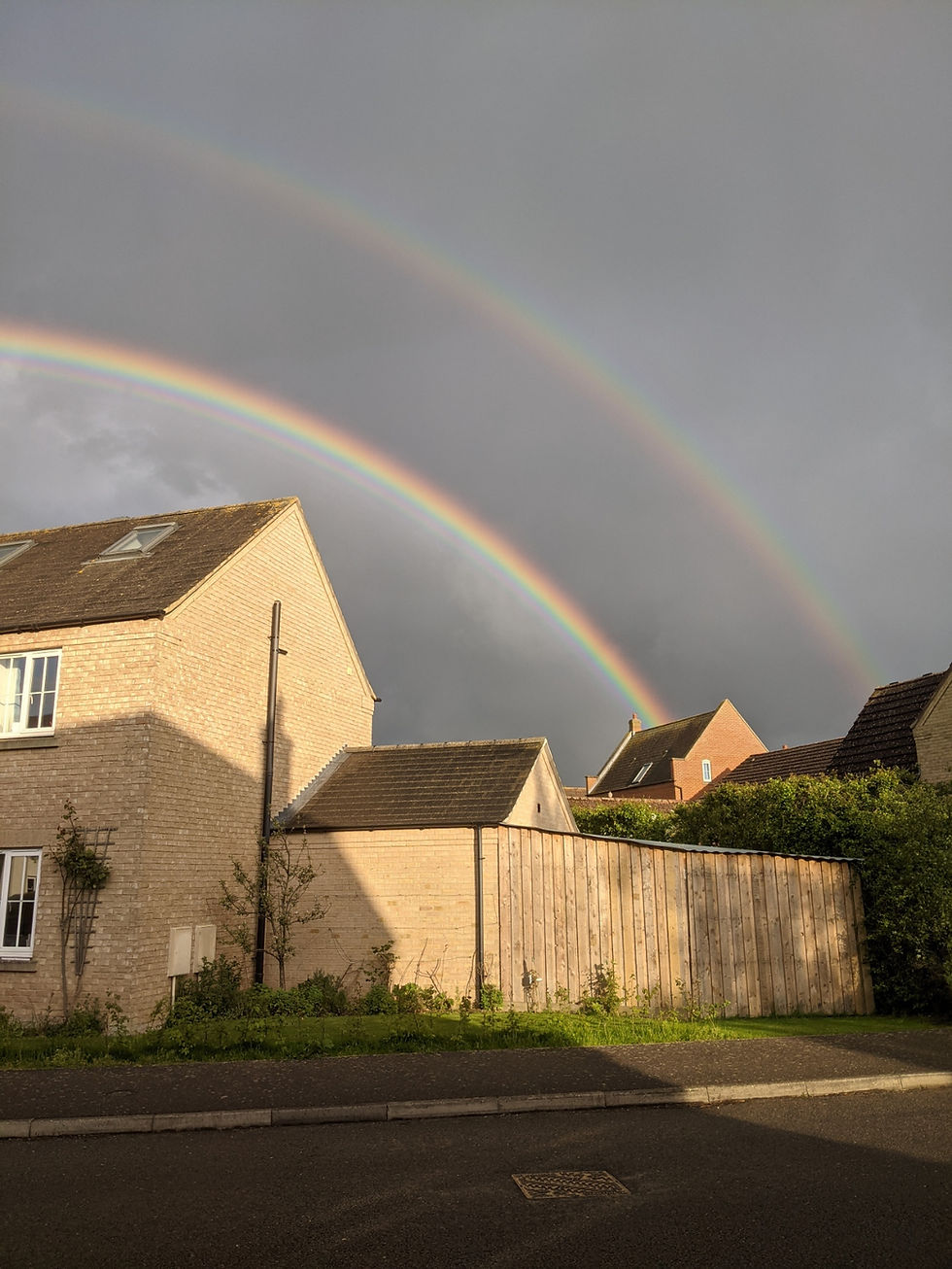 Modern brick house with double rainbow overhead