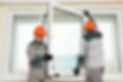 Two workers installing a new window unit