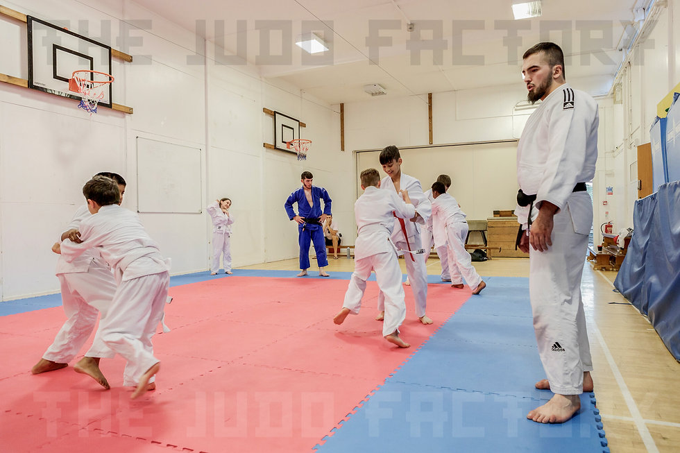 Judo coach watching children practise