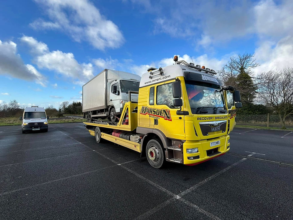 A small truck on a recovery vehicle