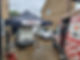 A classic car being worked on under a rain shelter