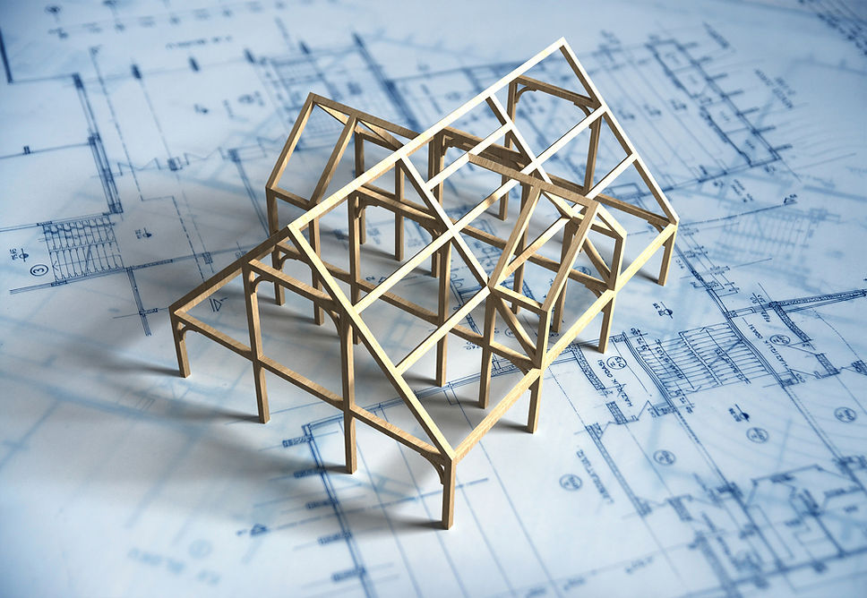 Wooden frame model of a building on a blueprint
