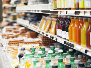 Regal in einem Supermarkt mit Getränken und Convenience-Produkten, viele davon auf Fruchtbasis – Saft, Smoothies und gekühlte Drinks.