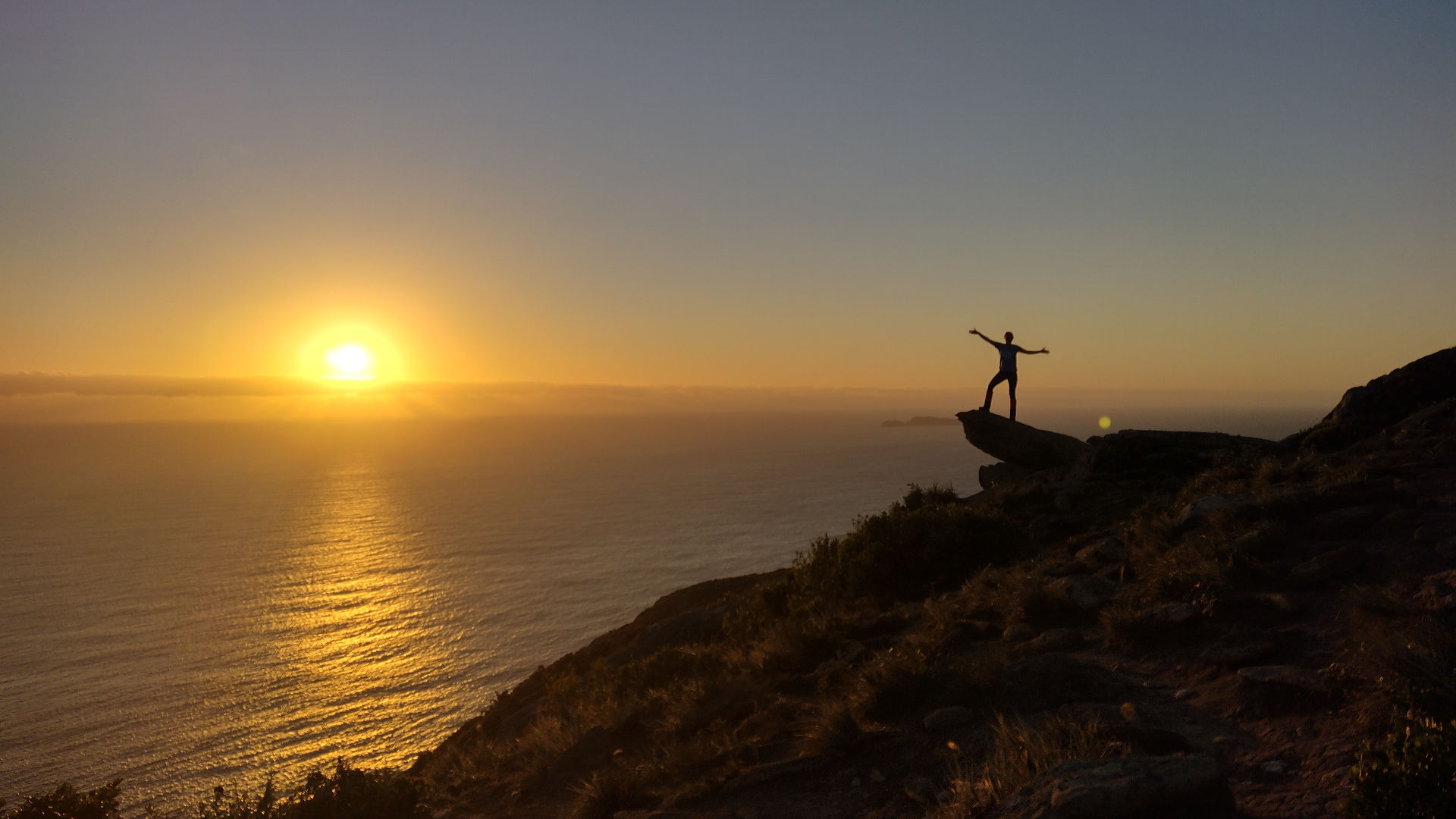 Mulher sobre uma pedra no Morro da Coroa no nascer do sol