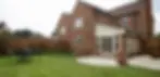 View of a house with a back garden and patio