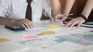 Professionals working with documents and calculating finances on a table