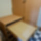 Open empty wooden drawer in a kitchen with cabinets and checkered floor