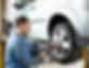 Mechanic fitting a car wheel in a workshop