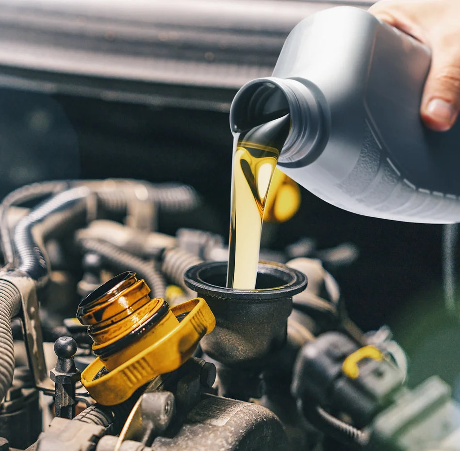 Close-up view of a person adding the engine oil