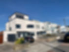 Modern white apartment building with cars