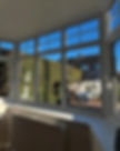 Bright bay window view showcasing greenery and outdoor furniture, with sunlight streaming into a cozy room