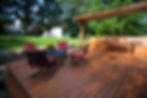 A wooden deck with a landscaped and sitting area