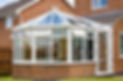 Conservatory with glass roof against a red brick house