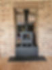 Wood-burning stove within a brick archway, on a black hearth, with a wood floor
