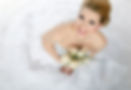 A joyful bride poses elegantly, radiating happiness in her beautiful wedding attire