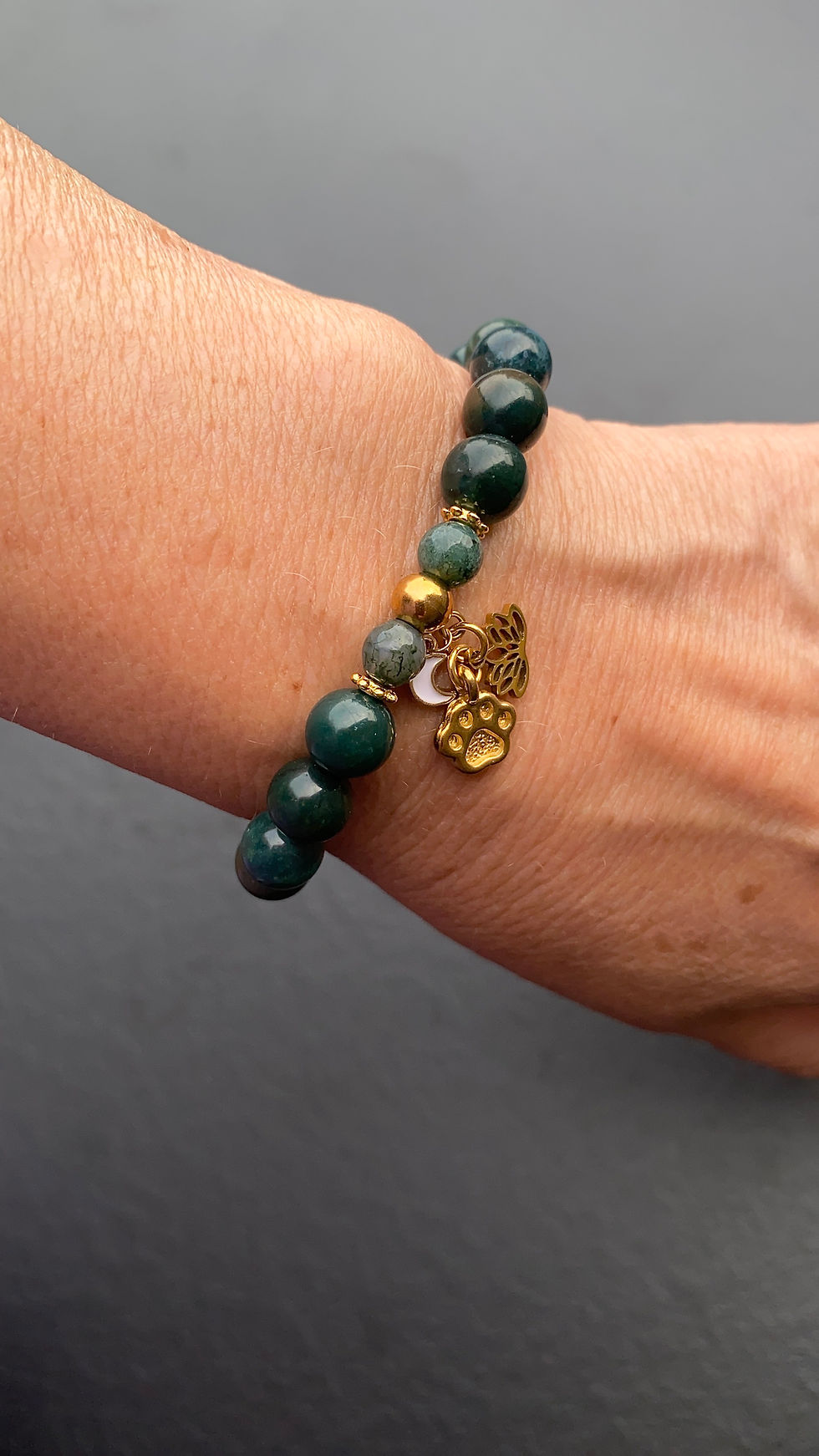 Miniaturbild: Nahaufnahme goldene Charms Pfote, Lotus & Mond – Symbol für Herzverbindung & Mut