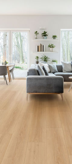 Bright open-concept living room showcasing Oak Hollow AQ516 AquaPro Max 15mm waterproof laminate flooring by Lago Flooring for custom homes, interior design, and professional flooring installation.