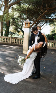 Elegant wedding couple posing on an outdoor terrace in Italy, bride with long wavy hairstyle and white wedding dress.