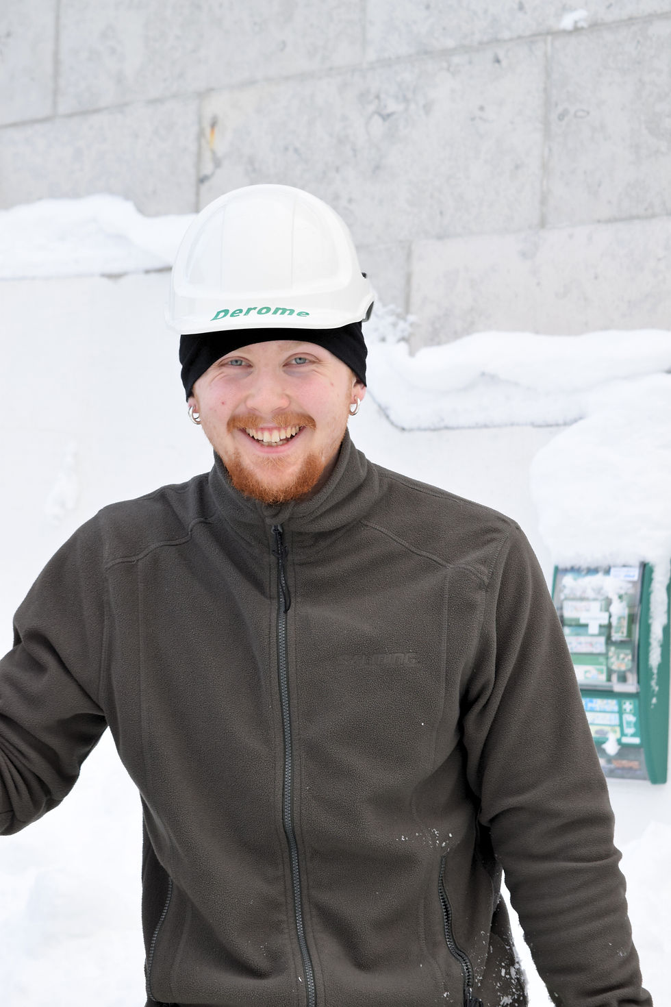 Glad, ung kille med fleecetröja och skyddshjälm.