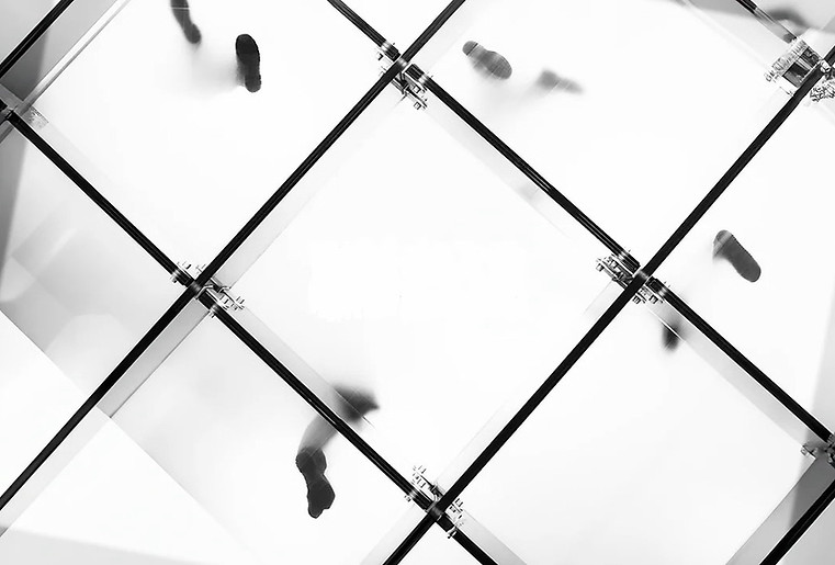 Glass floor with people walking on it seen from below