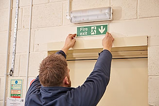 Ace Fire1 working installing a fire exit sign