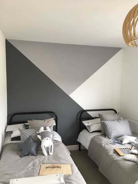 Bedroom wall painted with shades of grey triangles