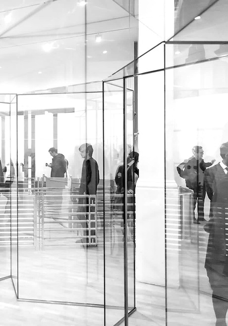Glass architecture with people stood behind