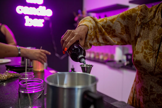 Candle Making Workshop at Einnim Candle Bar near Chicago where wax is being poured and measured while mixing essential oils for soy wax candle making.