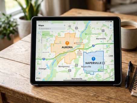 A digital map interface on a tablet highlighting the Aurora and Naperville areas, resting on a wooden table next to a notebook.