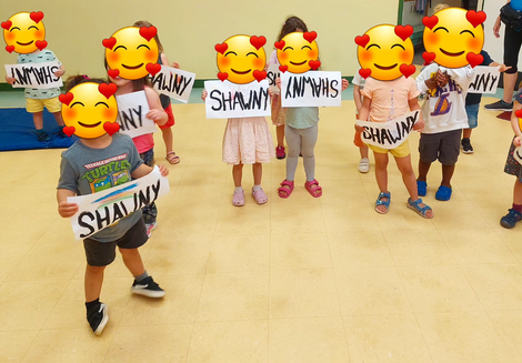 A group of children hold signs saying 'Shawny'