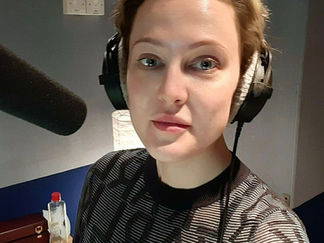 Liv Hansen in voiceover booth — recording in Copenhagen, headphones and microphone visible