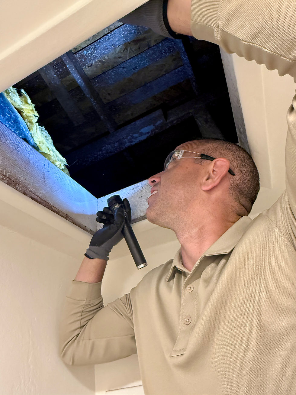 Caleb opening the hatch of an attic to take a look for pest activity