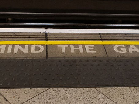 ロンドン地下鉄のホームに描かれた「MIND THE GAP」の黄色いラインと文字。電車とホームのすき間に注意を促すサイン。