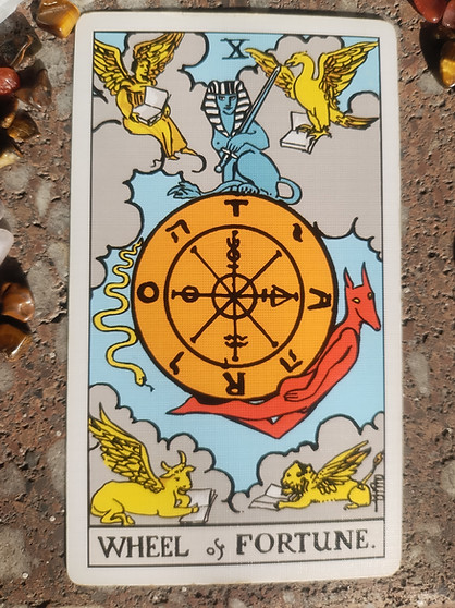Wheel of Fortune tarot card from Rider-Waite deck showing spinning wheel with sphinx and creatures