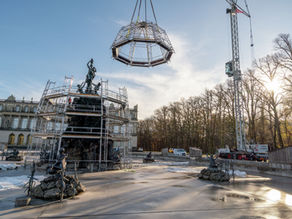 The MK 88-4.1E mobile construction crane from BKL is erecting a scaffolding canopy over a historic fountain with figures in the park of Herrenchiemsee Palace.