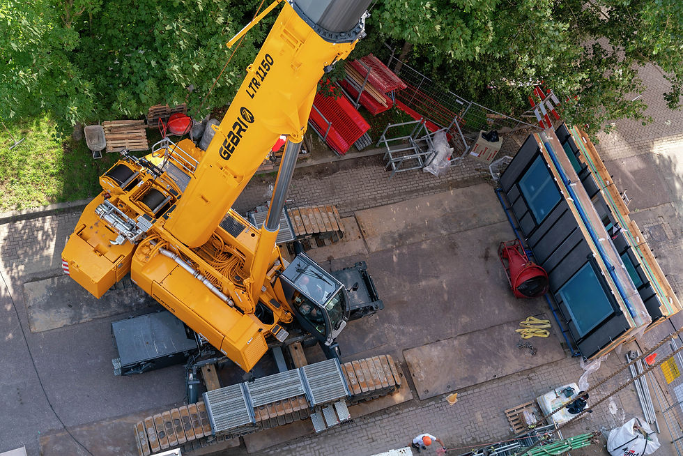The crawler crane rolls on steel plates closer to the delivery heavy-duty transporters to unload the components.