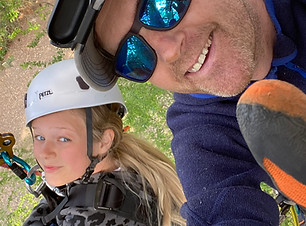 Dad and daughter climbing a tree