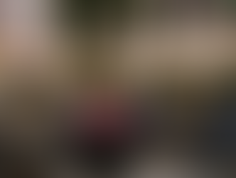 Cozy courtyard with pink hydrangeas, lanterns on tables, and cushioned chairs. Greenery and warm lights create an inviting atmosphere.