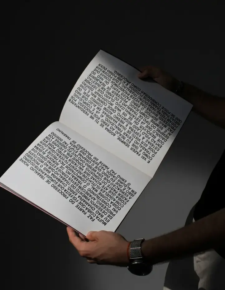 Open book with bold block text explaining the engineering design process, held by a person in dark clothing.