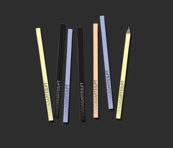 Seven colored pencils arranged vertically on a dark background, each printed with “CASADASARTES.PT.”