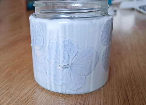 De lijm is op de gedroogde hortensia’s gelakt voor de glazenkaarshouder gemaakt door Lady Nature.