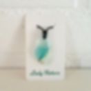Glazen hanger met zeegezicht. Azuur blauwe en creme witte tinten in het glas. De hanger hangt aan een zwart waxkoord.